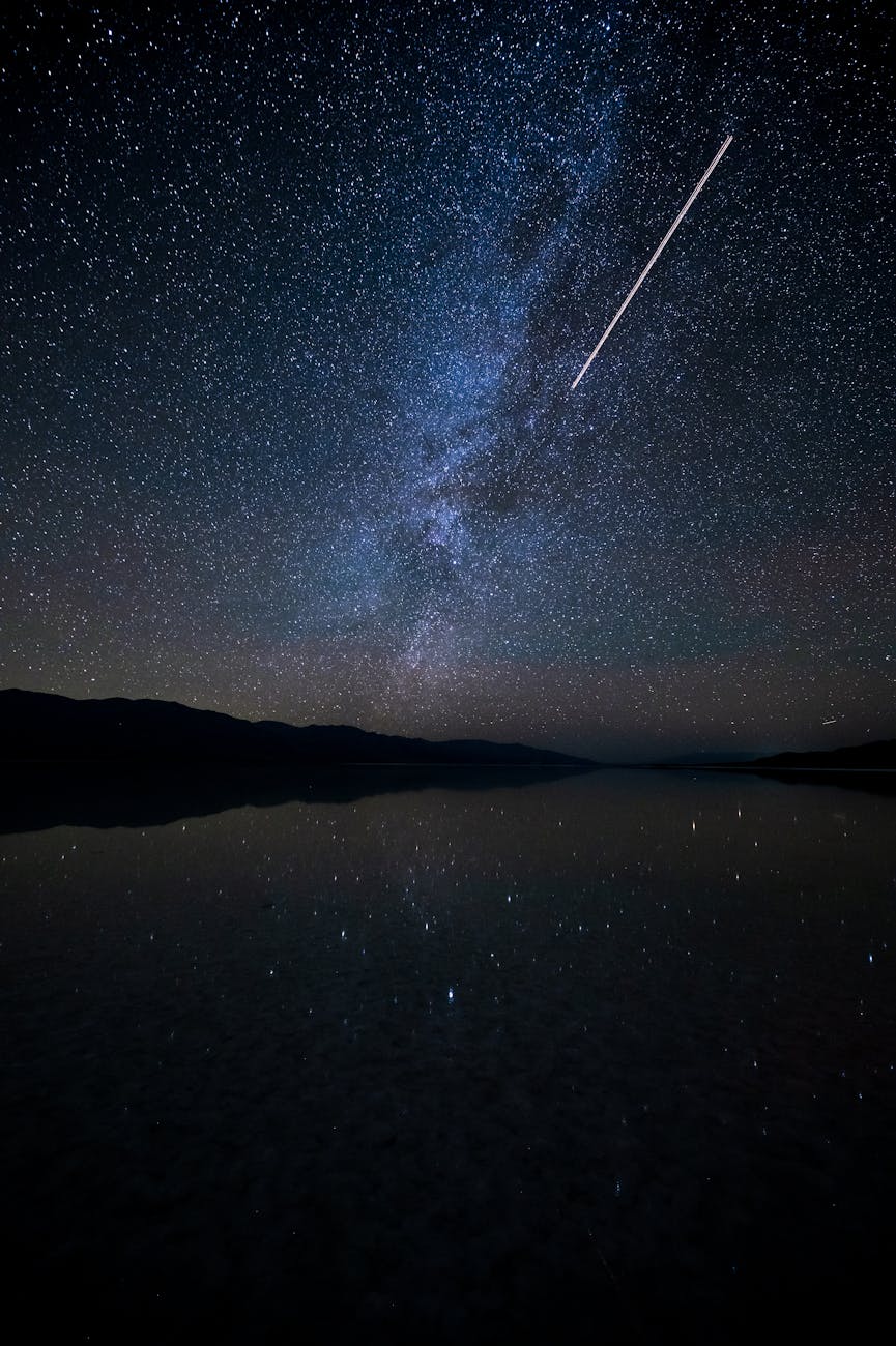 view of a starry night sky above a body of water